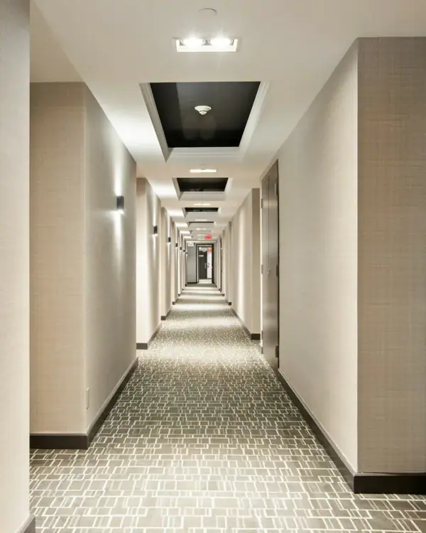 A long hotel corridor with rows of guest-room doors
